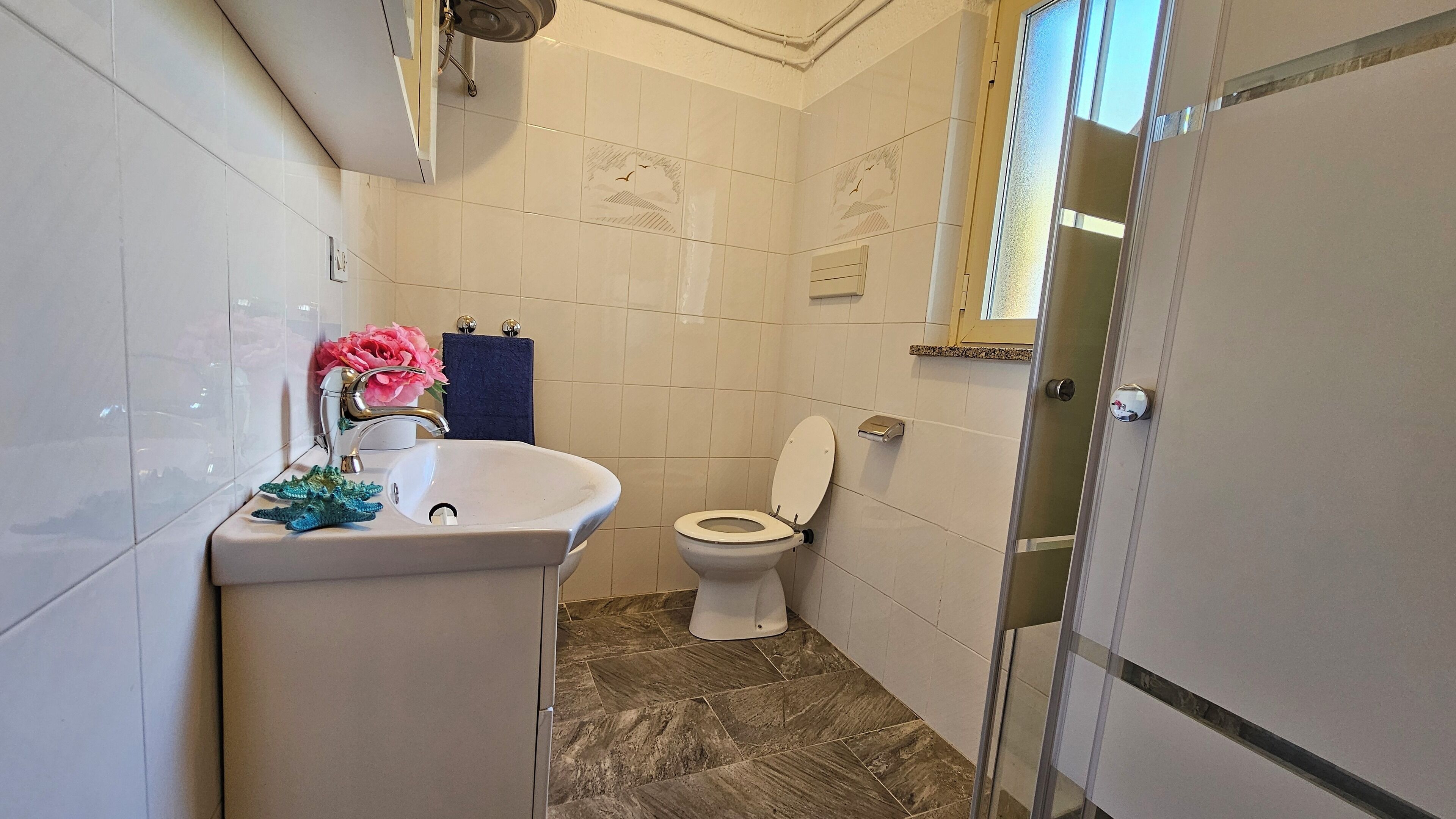A bathroom with a white sink, a toilet, and a shower area.