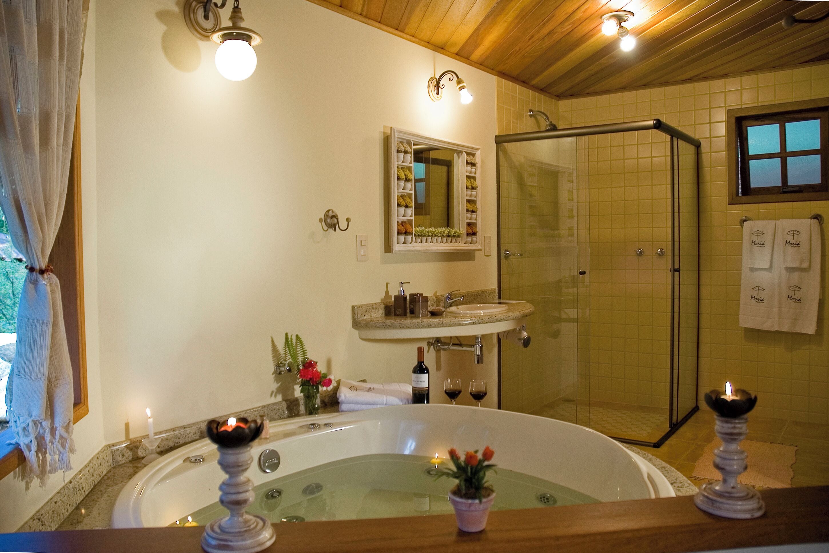 A bathroom with a bathtub, a shower, a sink, and a mirror.