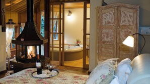 Una habitación con estufa de leña, bañera y un armario de madera.