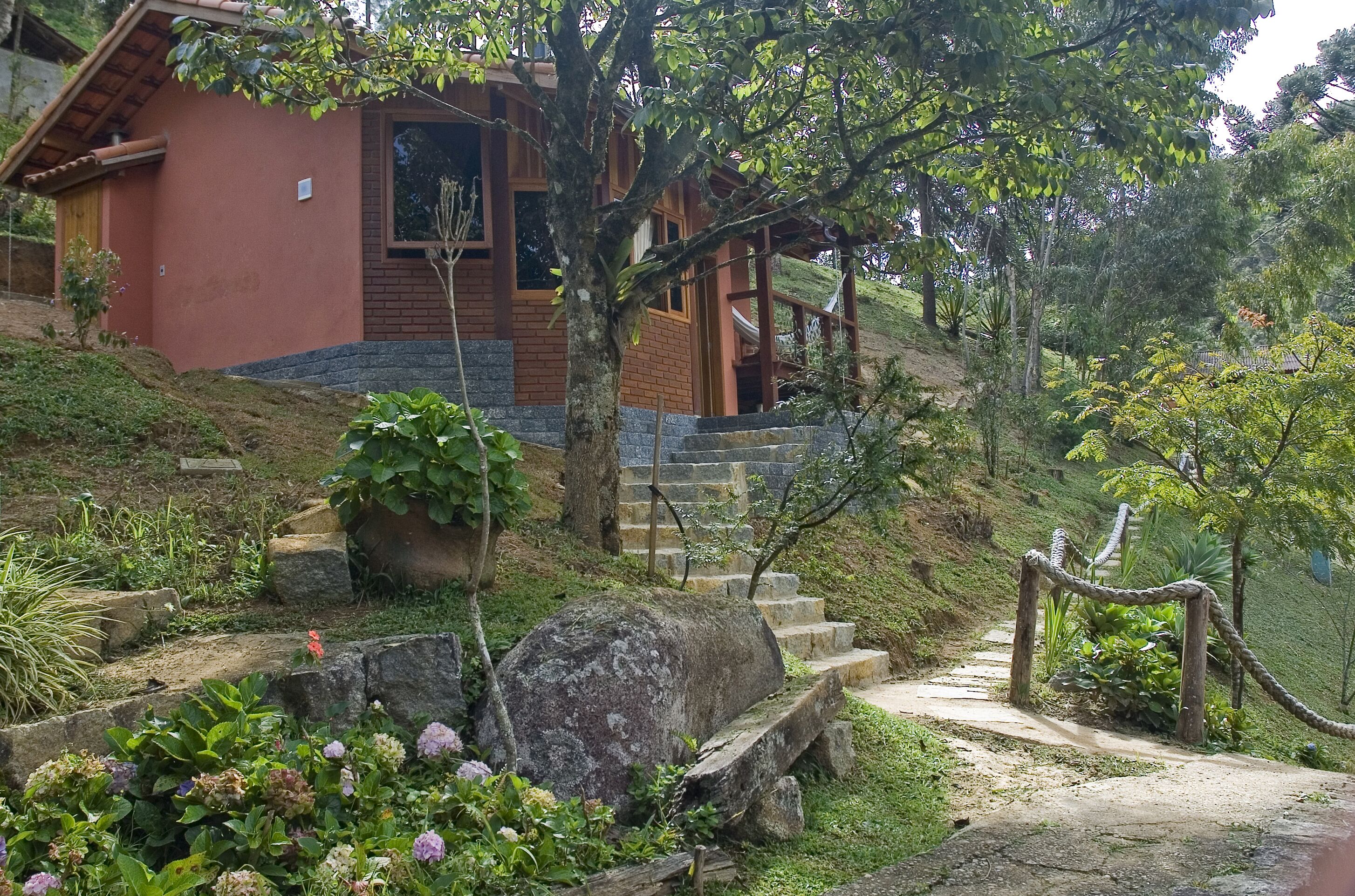 Un edificio rústico con fachada de ladrillo, escalones de madera y un sendero de piedra que conduce a un portón de madera.