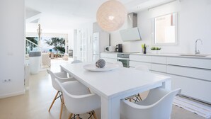 A modern kitchen with white cabinetry, a large island, and a hanging light fixture. - PORT NOU CA NA CATI - Chalet with sea views in Cala Bona. Free WiFi (Son Servera)