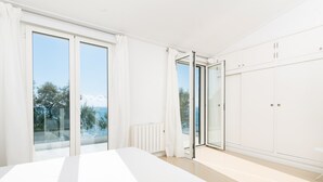 A modern bedroom with a large bed, sliding glass doors to a balcony, and a white wardrobe. - PORT NOU CA NA CATI - Chalet with sea views in Cala Bona. Free WiFi (Son Servera)