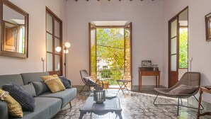 A cozy living room with a sofa, armchairs, a coffee table, and a view through a glass door to a balcony. - CA SA TIA (SÓLLER) - Townhouse with nice patio in the centre of Sóller. Free WiFi (Sóller)