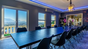A conference room with a long table, chairs, and large windows offering a city view. - Cape Grandeur (Cape Town)