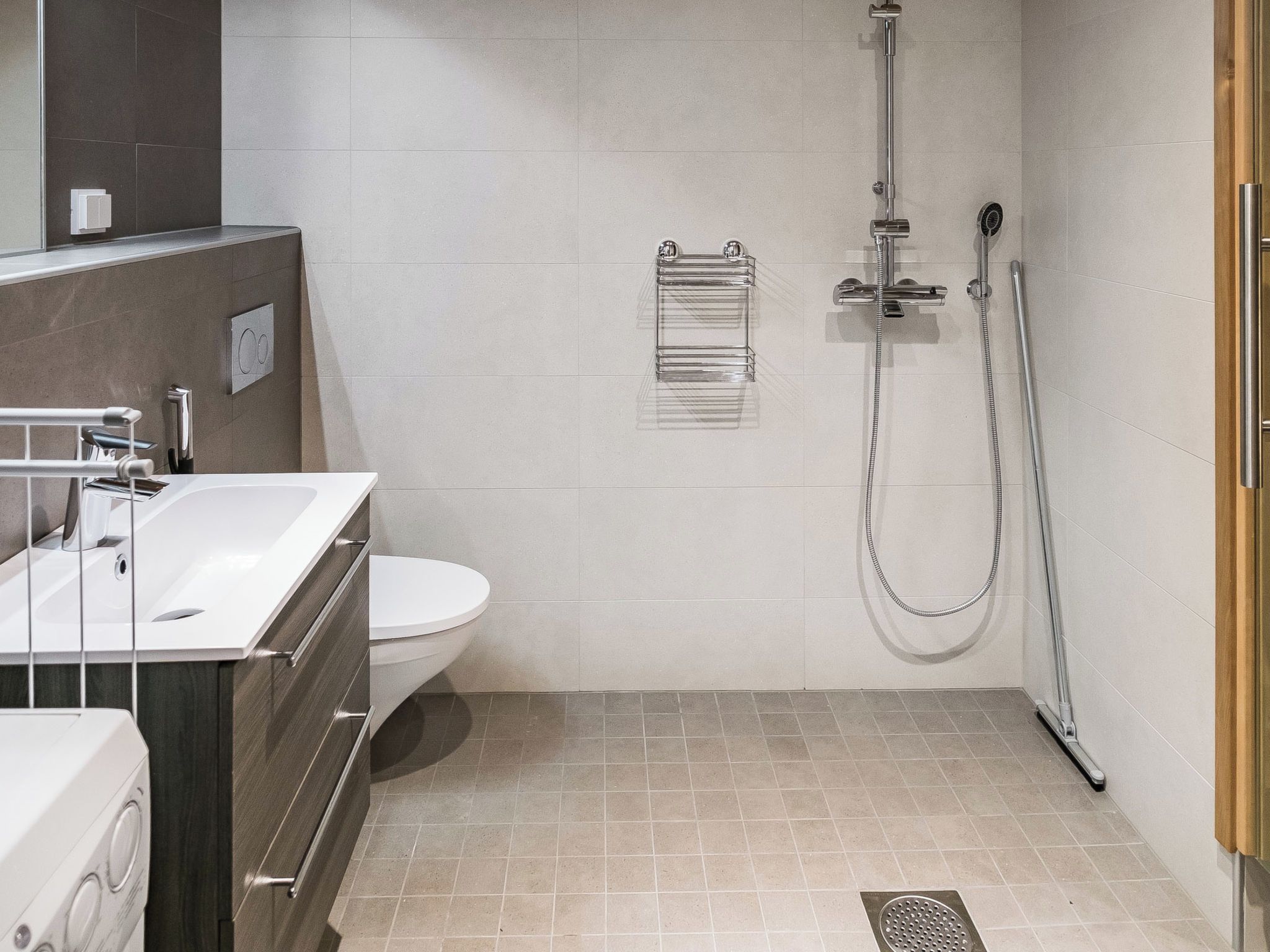 A modern bathroom with a shower, toilet, and sink.