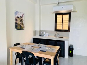 Cozy room with a kitchenette, dining table, and comfortable seating for four.