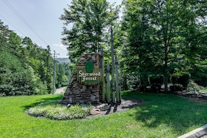 A stone sign with the text "Sherwood Forest" surrounded by lush greenery and trees. - Summer weeks reduced! Gated Resort, 6 Master Suites, Community Pool, Hot Tub! (Pigeon Forge)
