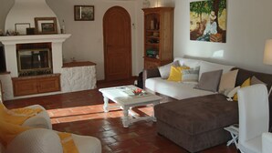 Ein Wohnzimmer mit Kamin, einem weißen Sofa, einem braunen Sofa und einem Couchtisch.