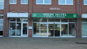A hotel with a green sign reading "Milde Hotel" and "In der Stadt der 100 Brücken". - Milde Hotel (Kalbe)
