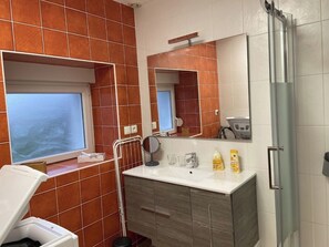 Ein Badezimmer mit großem Spiegel, Waschbecken und Dusche.