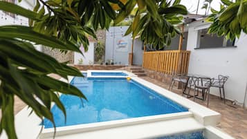 Una piscina al aire libre, sombrillas, tumbonas