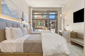 A modern hotel room with a large bed, a desk, and a view of the outside. - 3BR ski-in/out condo at Westin Riverfront with mountain and river views. (Avon)