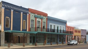 A row of colorful buildings with storefronts, including a visible sign for 'Blu-Buck Mercantile'.