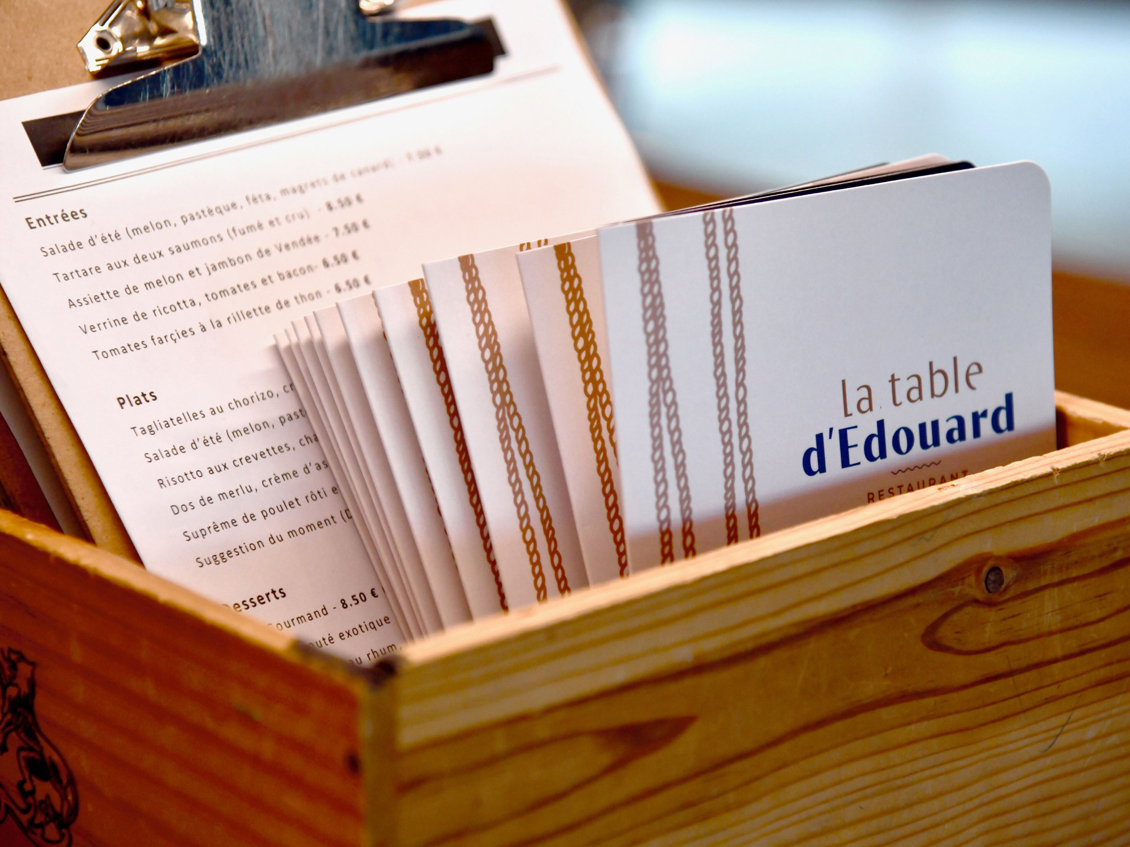 A wooden box with a menu from 'la table d'Edouard' restaurant.