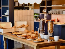 Une table de buffet proposant divers produits de boulangerie et une machine à café.