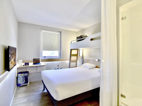 A compact hotel room with a bunk bed, a small bedside table, a window, and a wall-mounted TV. - ibis budget Nantes Rezé Aéroport (Reze)