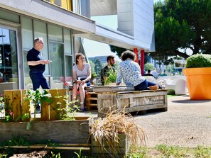 Un área de estar al aire libre con bancos de madera y plantas en macetas.