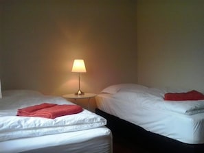 Habitación con 2 camas individuales, baño compartido | Cortinas blackout, wifi gratis y ropa de cama 