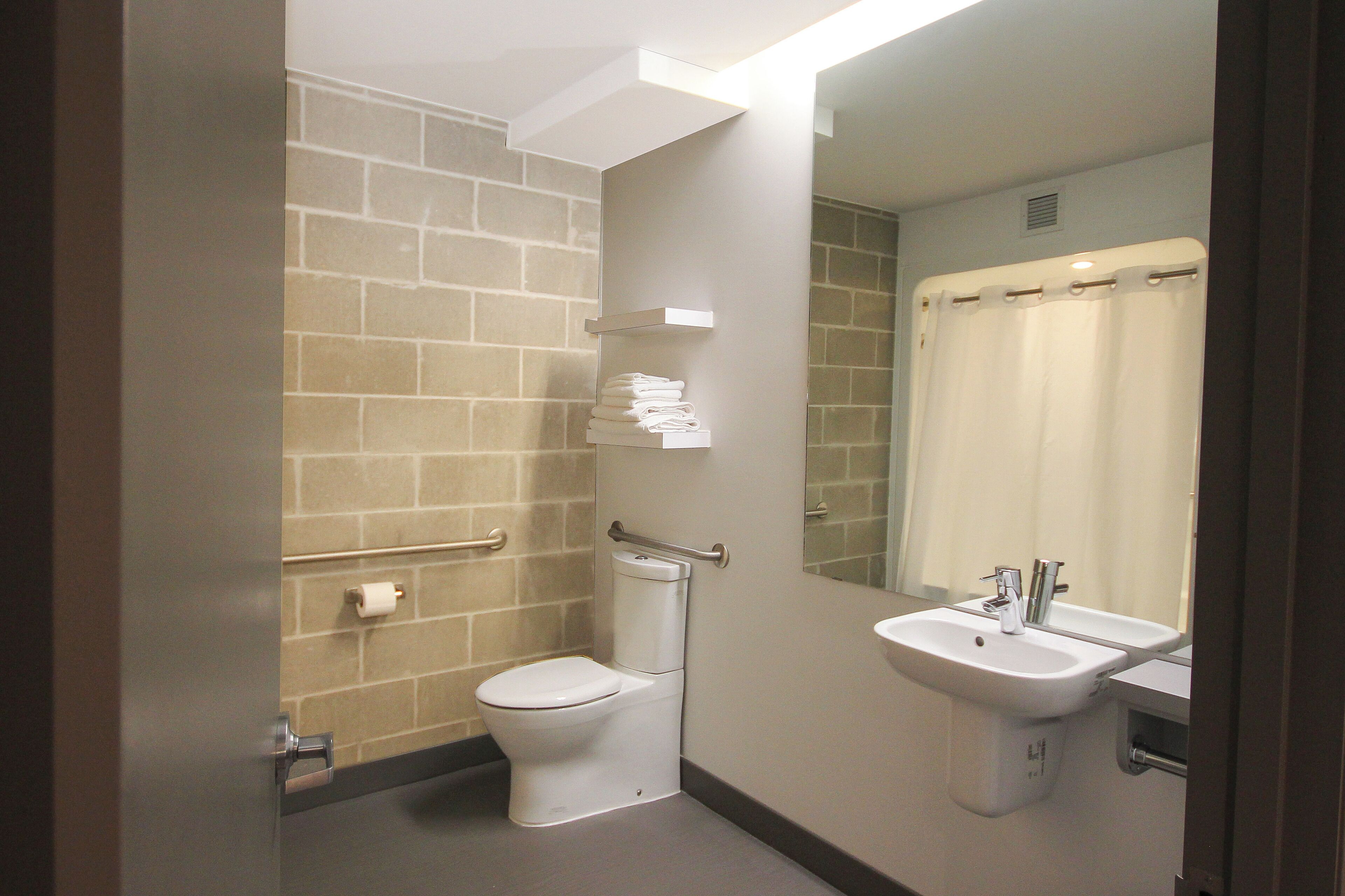 Une salle de bain avec des toilettes, un lavabo et un miroir.