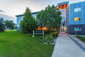 A modern building with a sign reading "Barker Building 100 Mesmer Road East." - Barker Suites Southport, an Ascend Collection Hotel (Portage La Prairie)