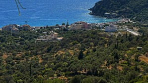 Une ville côtière avec des bâtiments, une plage et une chaîne de montagnes en arrière-plan.