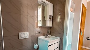 Une salle de bain moderne avec des toilettes, un lavabo et un miroir.