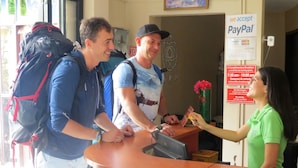 A reception desk with a sign indicating PayPal acceptance. - Dreamkapture Hostel (Guayaquil)