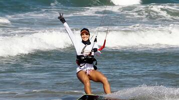 Uma pessoa praticando windsurf em uma prancha no oceano.