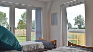 Una camera da letto con due letti, ampie finestre e vista sull'esterno.