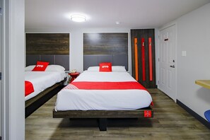 A hotel room with two beds, each with red and white bedding, a wooden headboard, and a bedside table with a lamp. - OYO Hotel Sulphur LA Hwy 90 West (Sulphur)