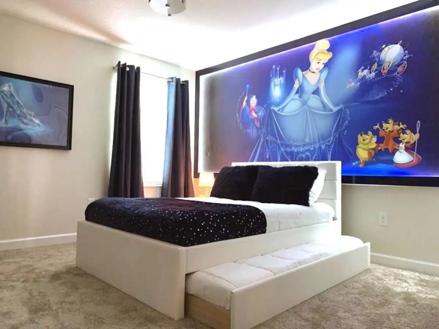 Une chambre avec un grand lit, un téléviseur à écran plat fixé au mur et un tableau accroché au mur.