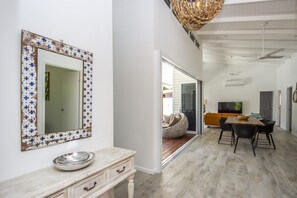 Un intérieur moderne avec un grand miroir, un coin repas et un téléviseur.