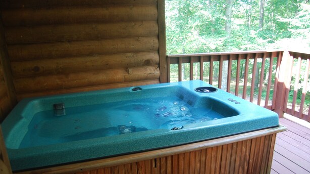 Eine Holzterrasse mit einem Whirlpool.