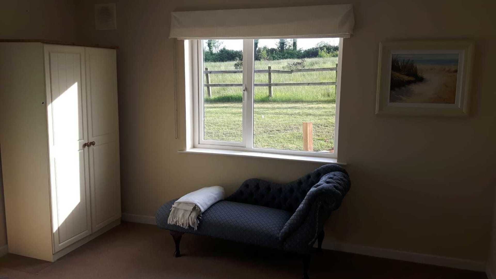 A room with a window, a bench, and a door.