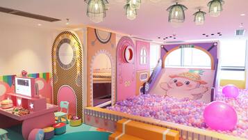 A children's play area with a ball pit, a slide, and a 'Welcome' sign.