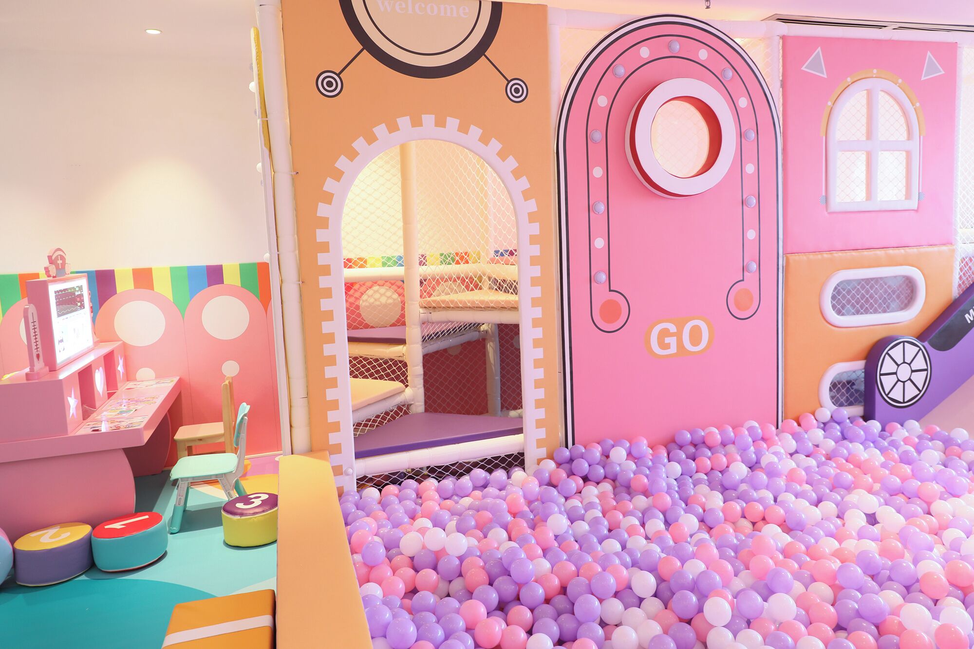 Zona infantil con piscina de pelotas, tobogán y casita.
