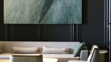 A modern living room with a large abstract painting, a sofa, two armchairs, and a coffee table.