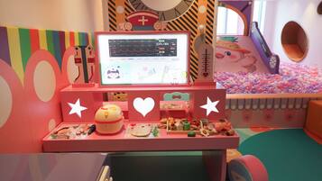 A children's play area with a computer monitor, toys, and a ball pit.