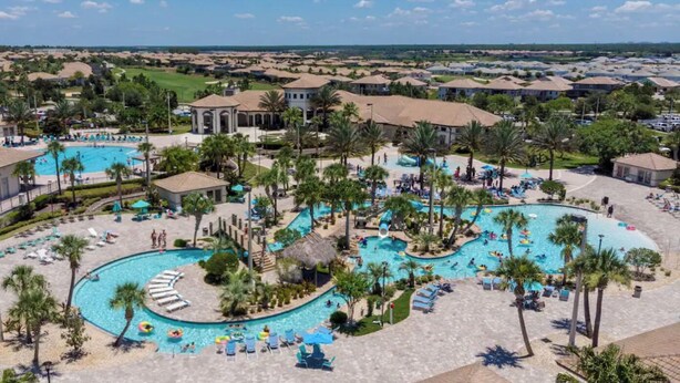 Ein Resort mit mehreren Schwimmbecken, Palmen und Blick auf die umliegende Landschaft.