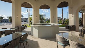 Ein Außenbereich mit Terrasse, Tischen, Stühlen und einer zentralen Bar, sowie gewölbten Decken.