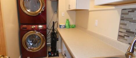 A compact kitchen with a double-washer unit, a sink, and a countertop with a few items.