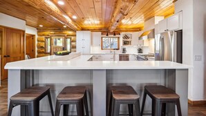 A spacious kitchen with a large island, wooden ceiling, and modern appliances. - Baldy Mtn Log Ski Home, Game Room, Free Shuttle, Sleeps 12 (Breckenridge)