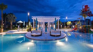 A swimming pool with a covered seating area, a water slide, and lounge chairs. - Fresh Heaven Pool Home by AV Dreams (Kissimmee)