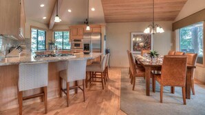 A spacious kitchen with wooden cabinets, a large island, and modern appliances. - Luxurious home on the golf course (Sunriver)