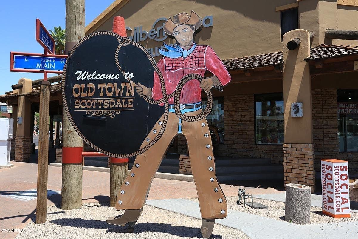 Señal de bienvenida a Old Town Scottsdale con una estatua de vaquero.