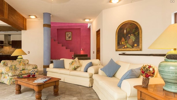 Una sala de estar con un sofá, una mesa de centro y un cuadro en la pared.