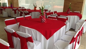 A banquet hall with round tables covered in red tablecloths, white chairs with red sashes, and floral centerpieces. - Hotel Cielo Azul (Cajamarca)