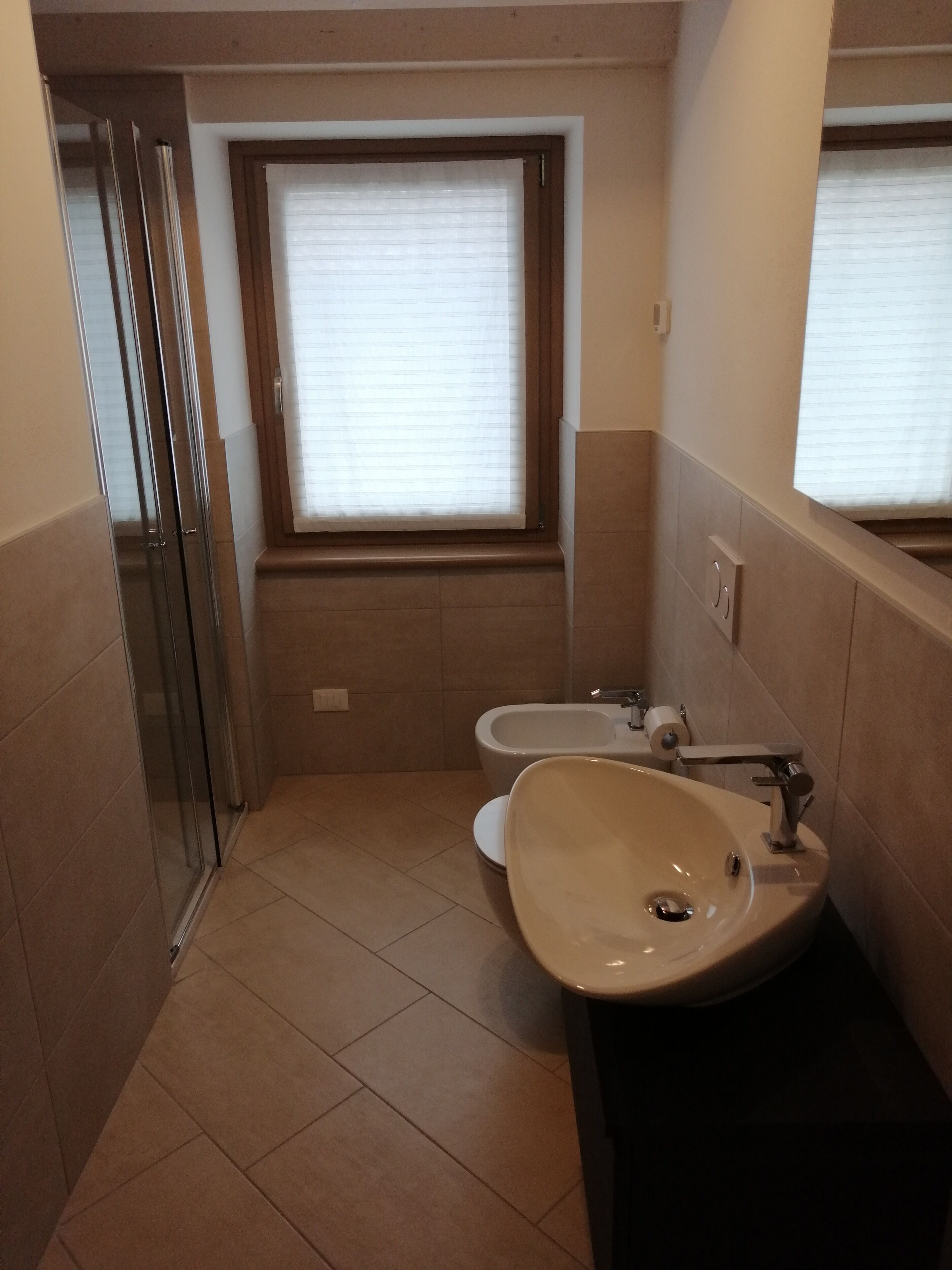 A bathroom with a toilet, sink, and shower.