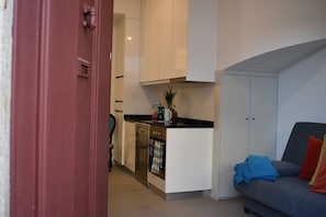 Cozy living space with a kitchenette, sofa, and adjacent room.