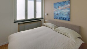 A bedroom with a large bed, a window with blinds, and a motivational poster on the wall. - Apartment Near Corso Buenos Aires, Milano Central (Milan)